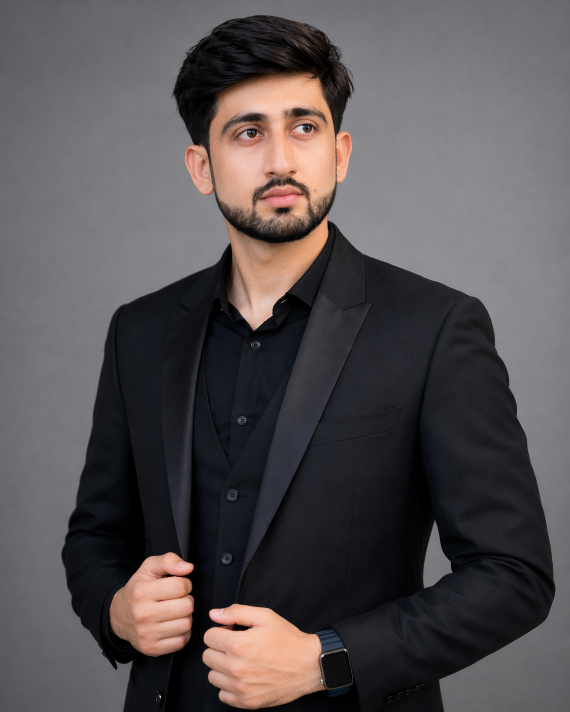 Sarfraz Saeed in a black suit with arms crossed